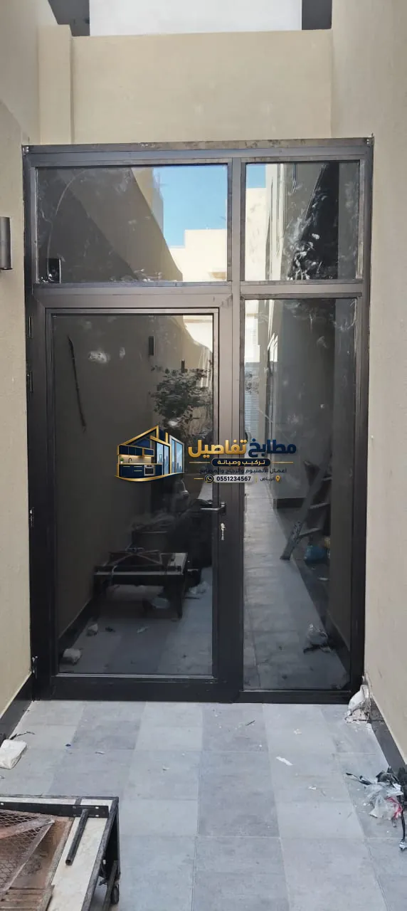 مدخل ألمنيوم وزجاج بإطار أسود وتنفيذ مخصص للممرات